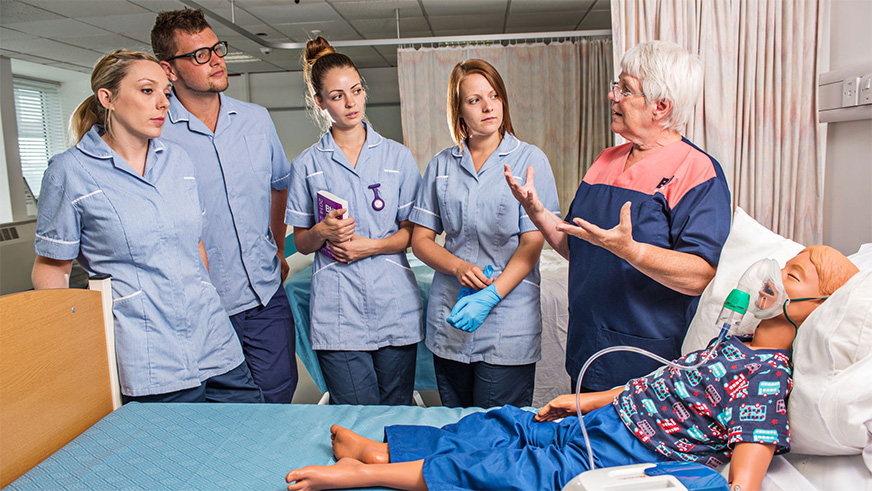 Nursing students with a dummy patient in one of the simulation suites within the building - designed to enable students to get hands-on and practice essential skills