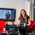 Young woman in front of a video camera