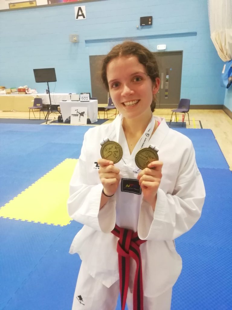 Immi Hand holding her two gold medals Immi Hand