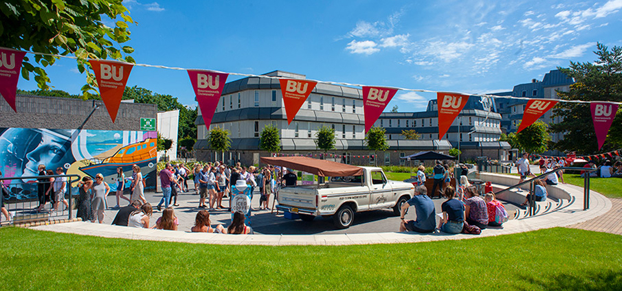 Open Day attendees gathered in a courtyard in the sun