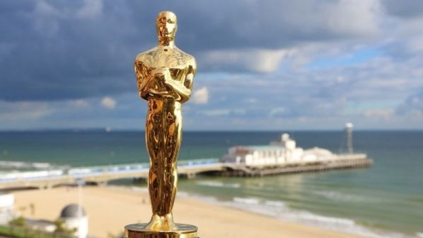 A close up of an Oscar with Bournemouth beach and pier in the background