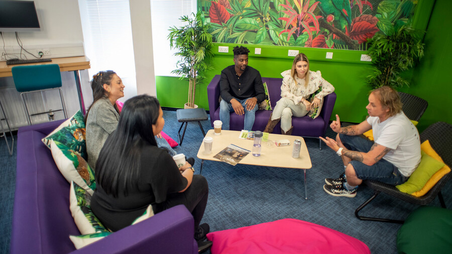 A group of students sitting on sofas in The Sir Michael Cobham Library. The Library offers a wide variety of spaces, from more formal study areas to those that are more relaxed