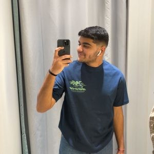 An image of Jain smiling in front of a mirror