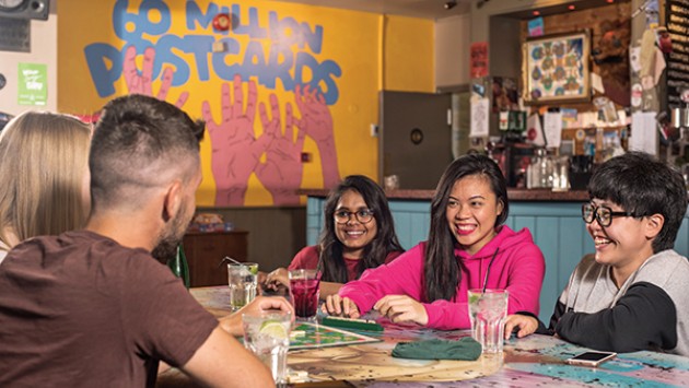 International students having a drink and conversation in Sixty Million Postcards, a popular bar and venue in Bournemouth