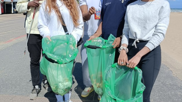group of students cleaning beach