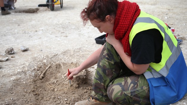 A student excavates skeletal remains  