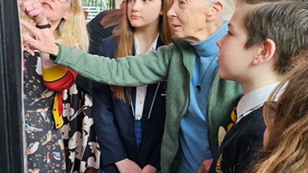 Jane Goodall showing children information for the Roots & Shoots project