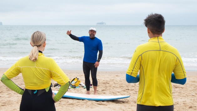 Image of a pair of students having a surf lesson at the beach