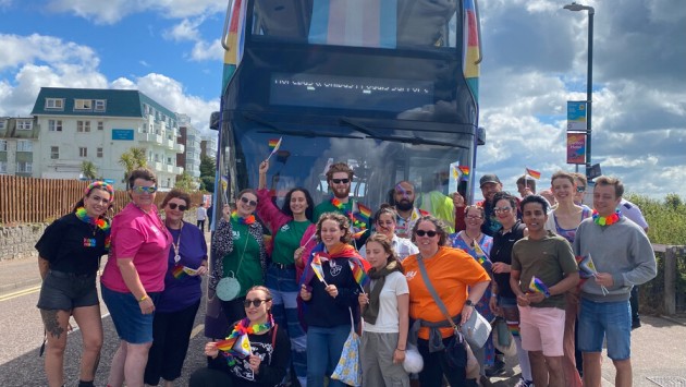 Members of the BU community standing in front of a Bournemouth University bus at Bourne Free 2024