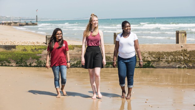 A group of postgraduate students walking along the beach