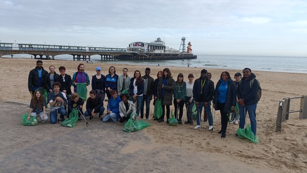 group of students cleaning beach