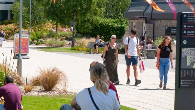 An Open Day on Talbot Campus, including people sat on the grass in the sunshine