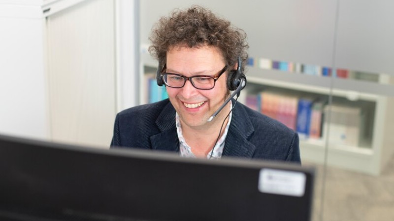 A member of the library team is answering a call on a headset