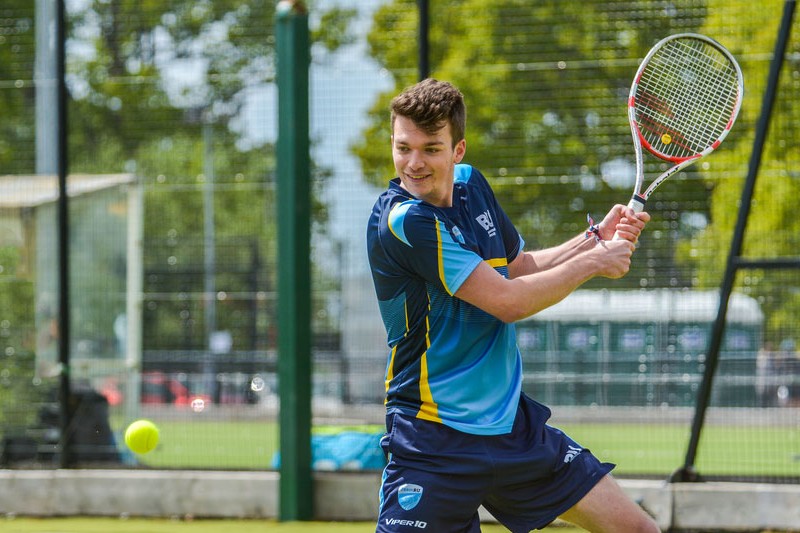 Student playing tennis