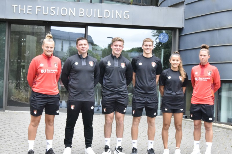 Academy team and AFC Bournemouth women's players standing outside a building on campus