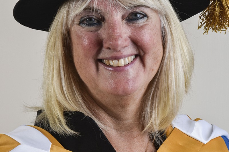 A lady in her ceremonial robes looking at the camera smiling