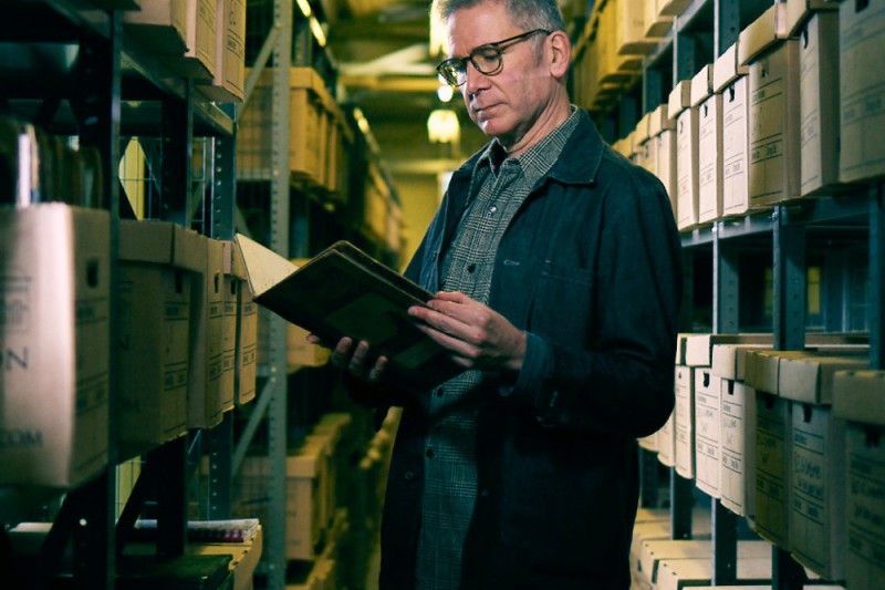 A picture of Dr Innes McCartney viewing the archive documents at the HEC