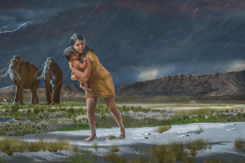 An illustration of a prehistoric woman holding a child with woolly mammoths in the background 