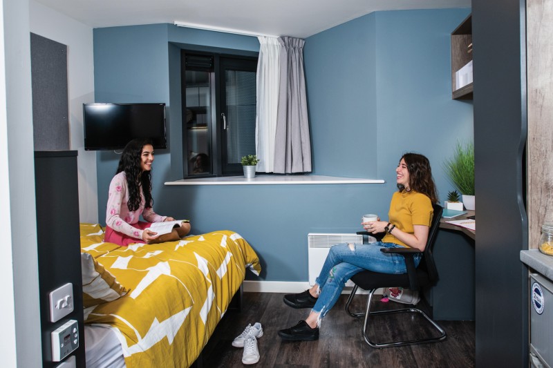 Two students having a cup of tea in a studio flat