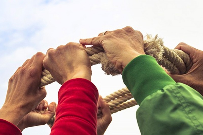 Hands holding a rope in a teamwork exercise