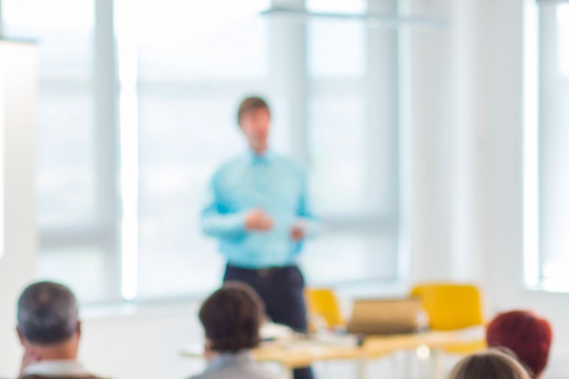 A man teaching a room of adults learners