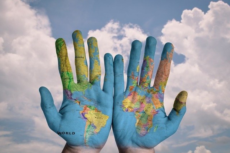 Hands painted with map of the world