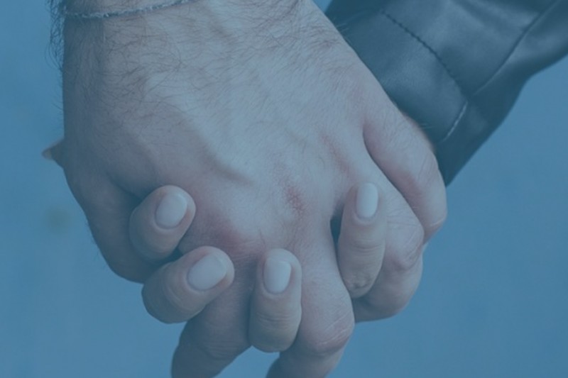 A close up of a man and woman holding hands