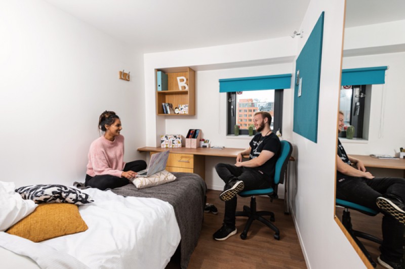 Two students chatting in a halls of residence room