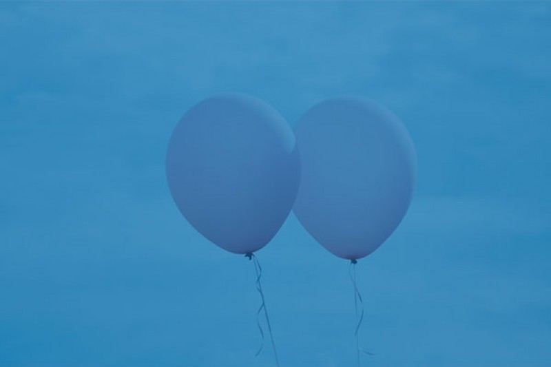 Two balloons behind a blue background