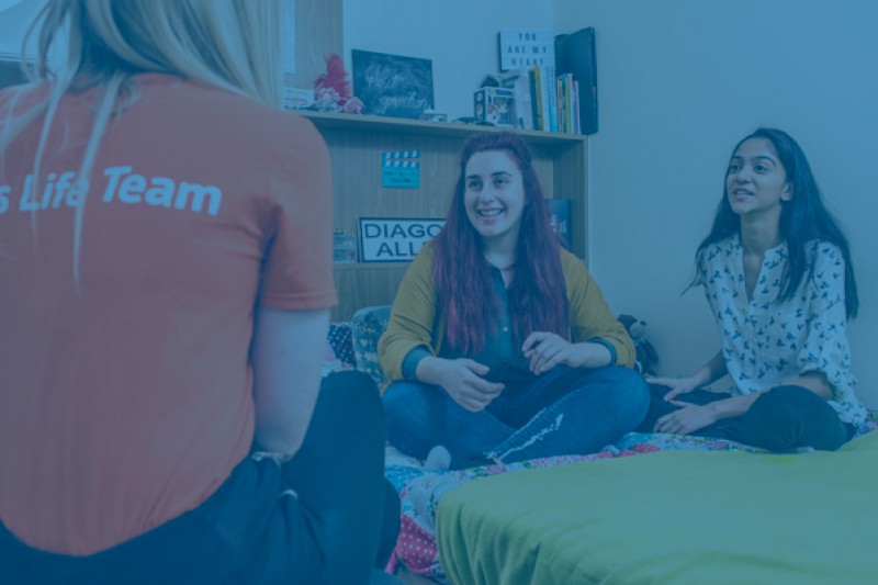 Three students talking in a halls of residence room