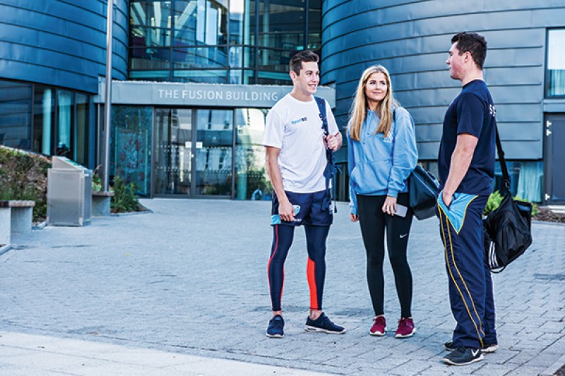Students outside the Fusion Building in SportBU gear