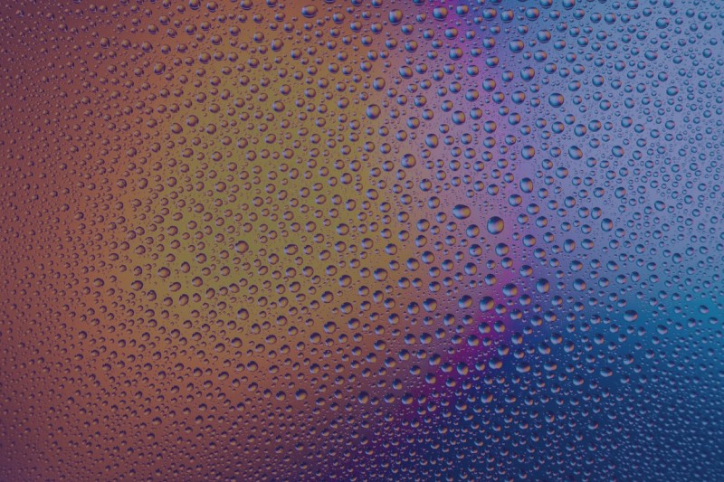 An image of condensation on glass with a bright light in the background