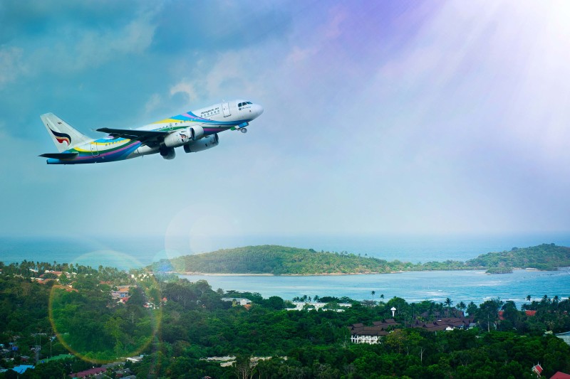 An aeroplane flying over a tropical landscape 