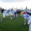 A group of men in american football kit, crouching down about to start play