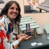 Angela holds her award next to a prototype of her reusable roof tiles