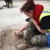 A student excavates skeletal remains  