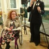 Former English student Charlotte Foder speaks at BU event, with microphone lowered to allow access from her wheelchair.