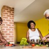 Three older black people around a table preparing vegetables