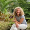 Julie Salt, a Bournemouth University graduate, sitting in green surroundings.