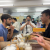 Louis, a BU Business & Management graduate, eating with colleagues in Vietnam