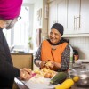 An older Asian couple preparing food in their kitchen 