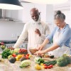 An older couple preparing fruit and vegetables in a kitchen 
