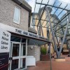 the outside of BU's talbot campus library is pictured on a sunny day from a low angle. the entrance doors feature as does the large glass covering