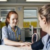 A nurse taking another the blood pressure of another nurse