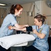 A nurse taking another the blood pressure of another nurse