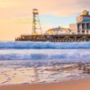 A shot of Bournemouth Pier in the background, taken from a low level on the beach with the tide rolling in in the foreground