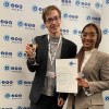 A man and a woman holding a certificate, looking at the camera smiling