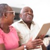 Two senior people looking at content on a tablet device and laughing