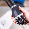 A robotic hand shaking hands with a human hand