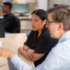 Student and library staff member looking at pc 